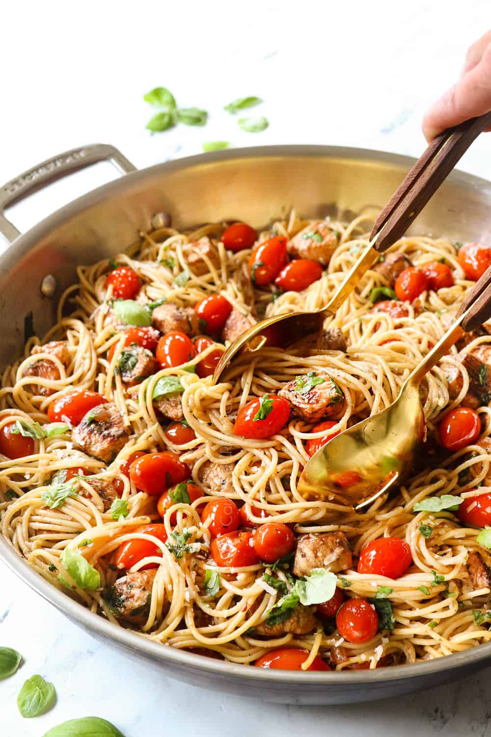 serving bruschetta chicken pasta recipe with tongs