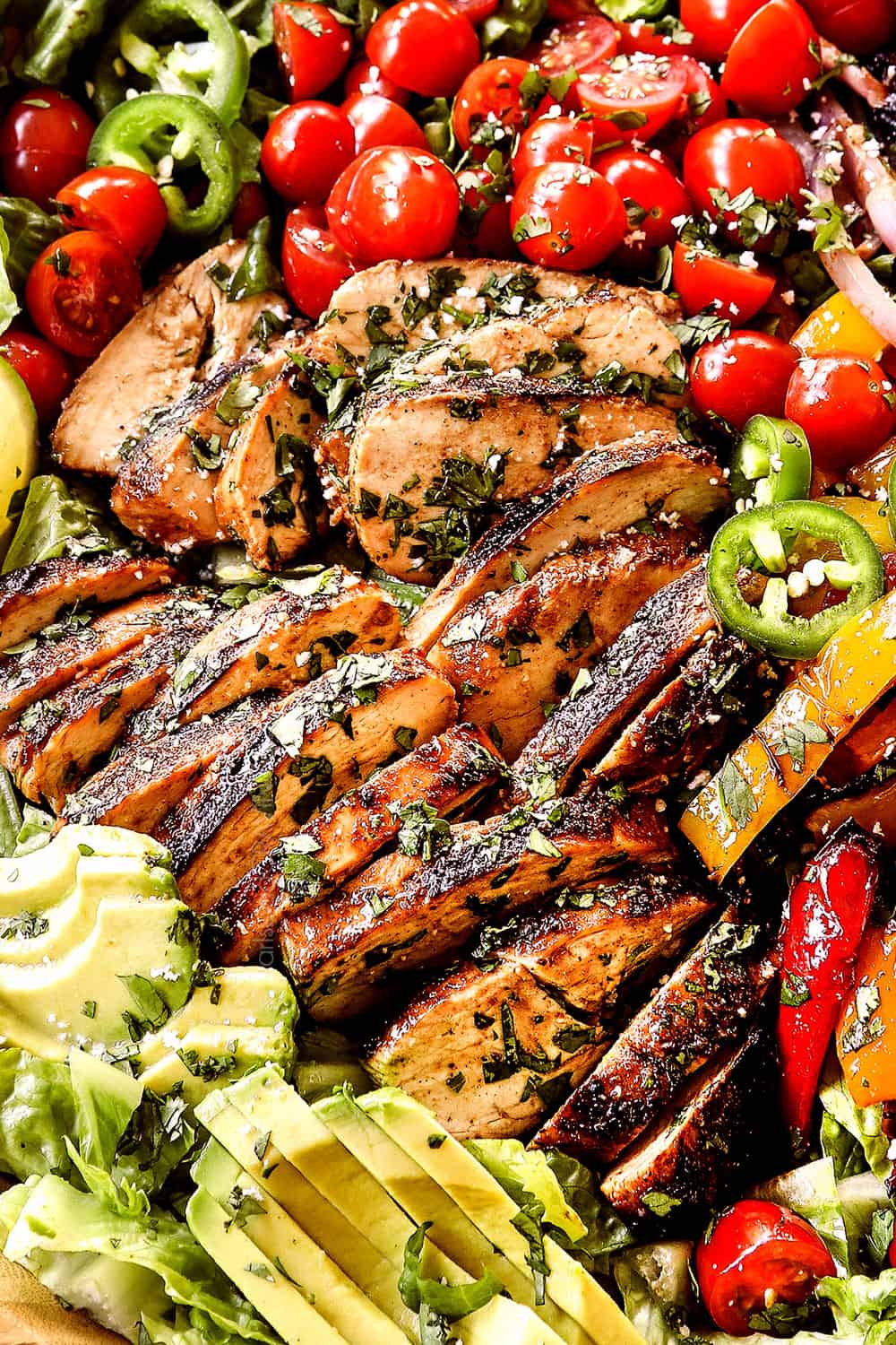 up close of juicy chicken in chicken fajita salad (chicken salad recipe) in a wood bowl