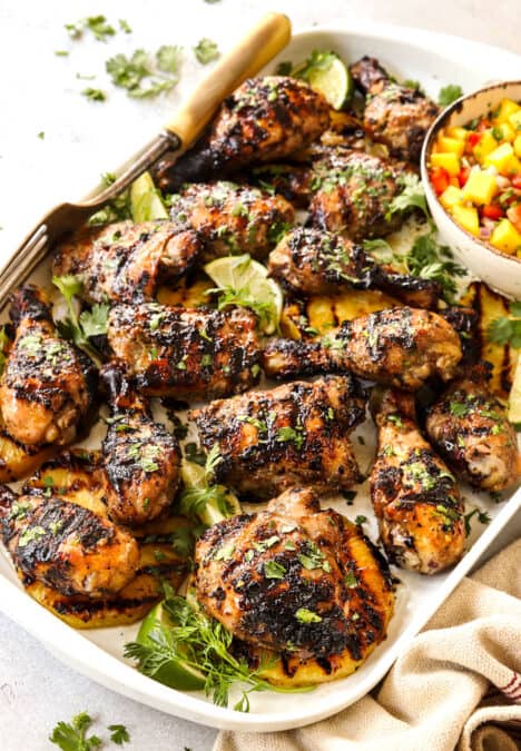 Jamaican Jerk Chicken on a white platter served with mango salsa
