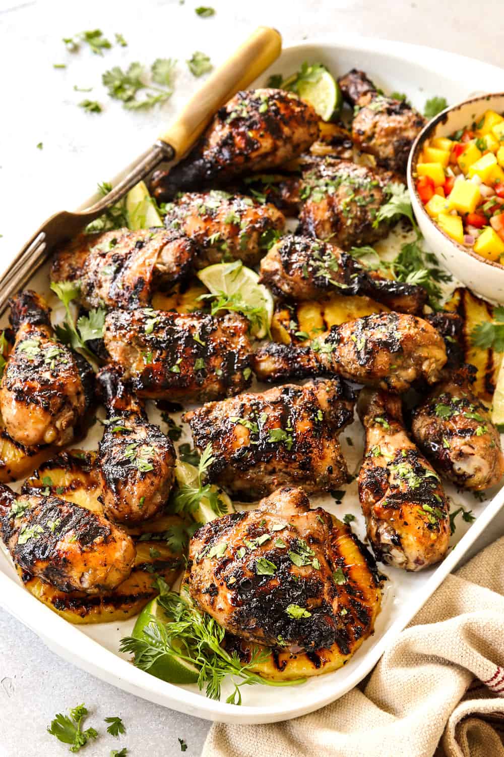 Jamaican Jerk Chicken on a white platter served with mango salsa