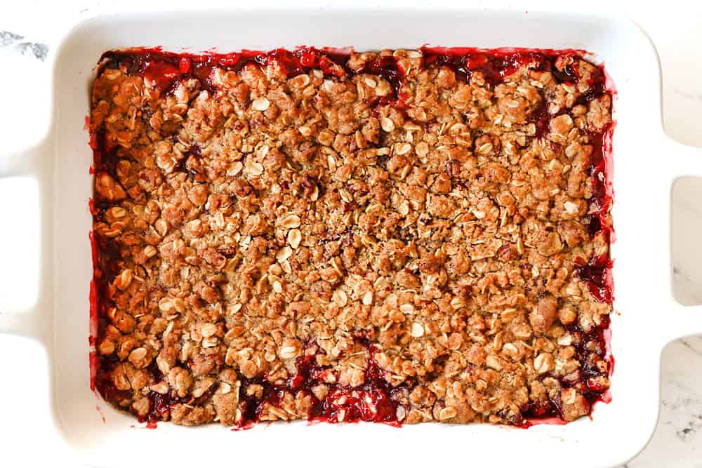 showing how to make strawberry crisp (crumble) by baking until the topping is golden and crispy