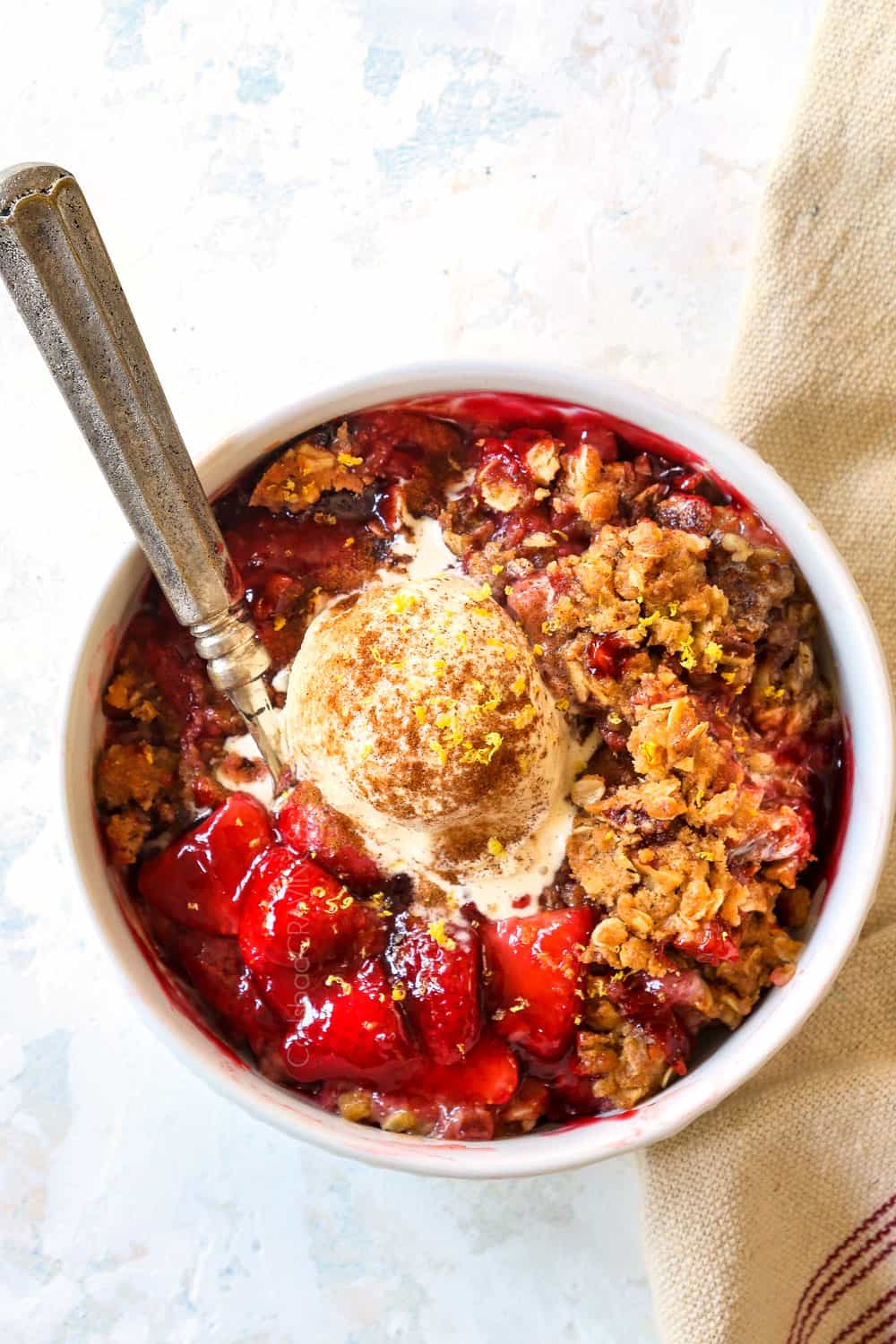 top view of strawberry crisp recipe in a white bowl with oats
