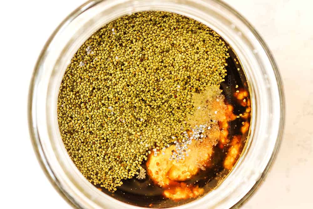 showing how to make watermelon salad recipe by adding balsamic dressing ingredients to a glass jar