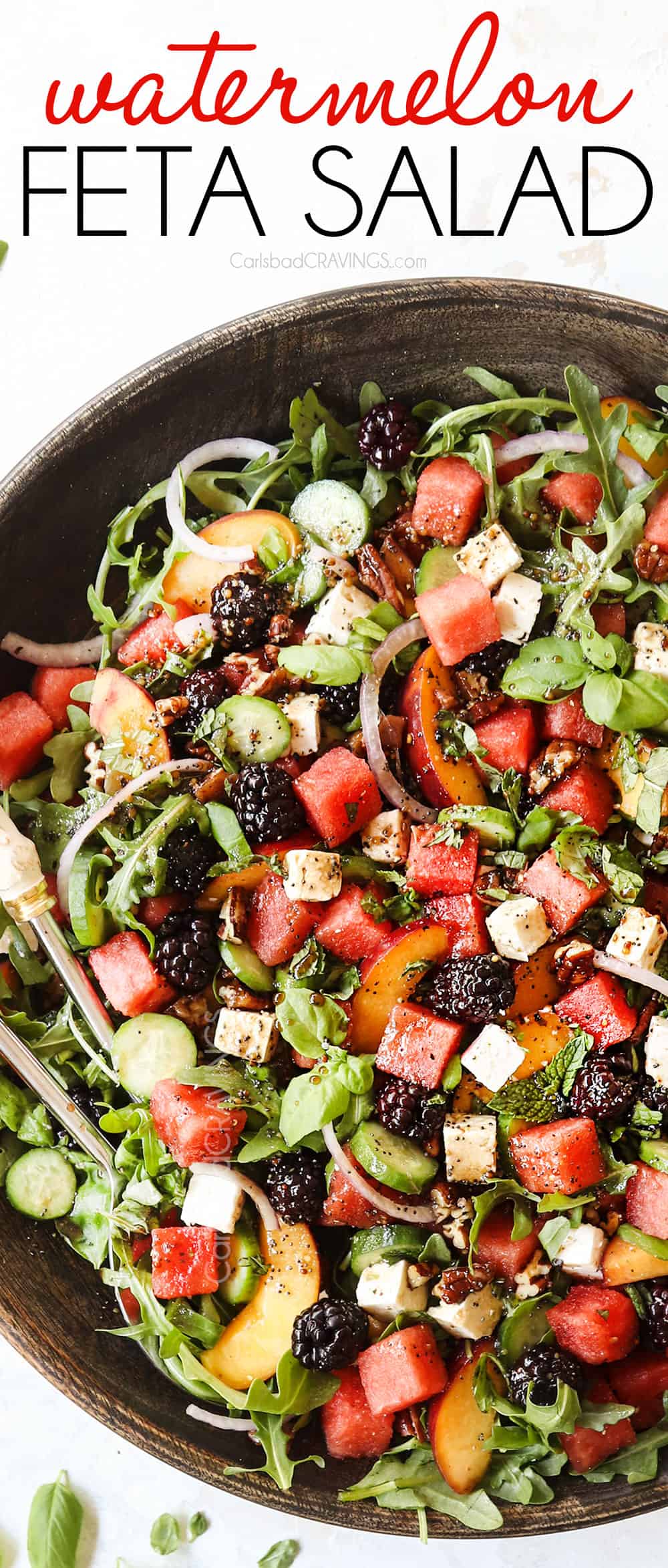 top view of a large serving bowl of watermelon salad with feta, basil, mint, cucumbers and arugula