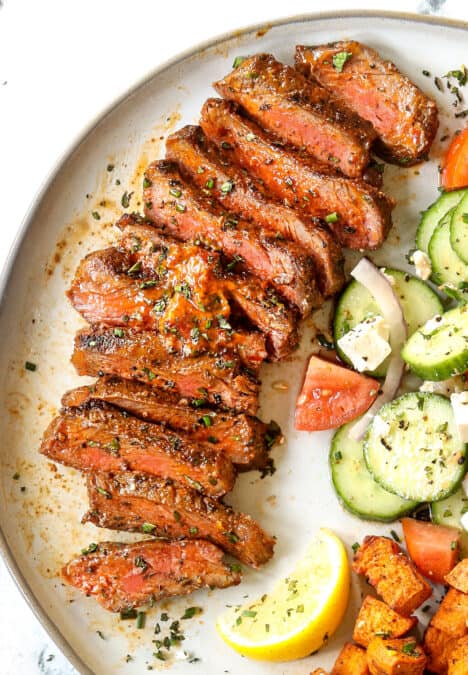 up close top view of New York Strip Steak (Strip Steak, NY Strip Steak) sliced on a plate with compound butter