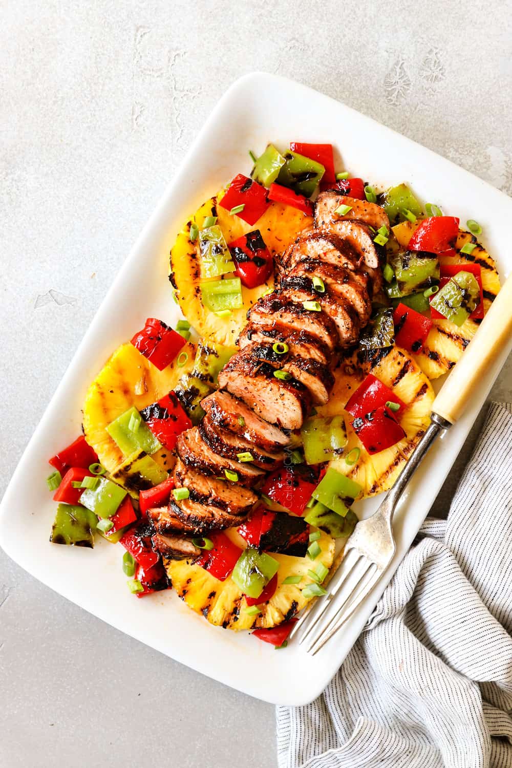 top view of marinated pork tenderloin sliced on a white platter with