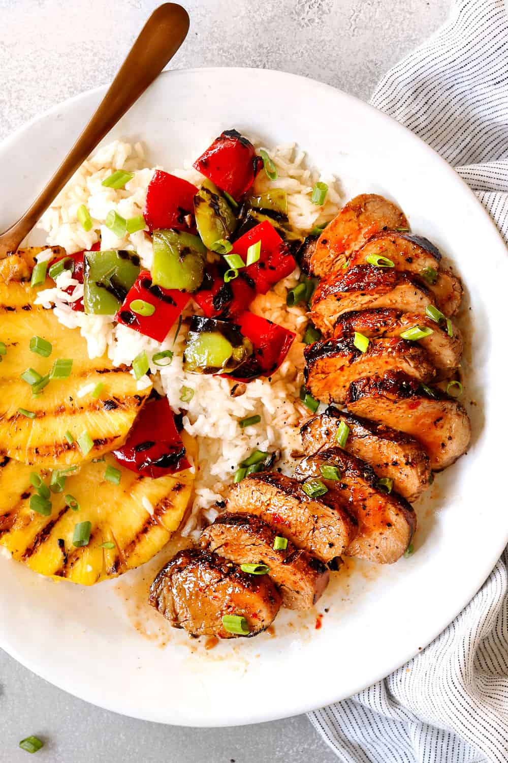 top view of marinated pork tenderloin sliced on a white plate