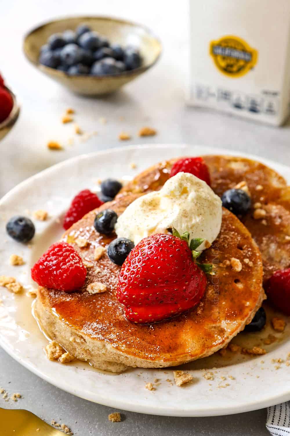 two cereal pancakes with cinnamon toast crunch on a white plate