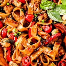 up close of Thai Drunken Noodles (Pad Kee Mao) in a with Thai bird's eye chilies, Thai basil, fresh wide rice noodles in a skillet