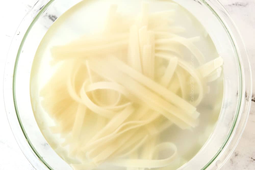 showing how to make Drunken Noodles (Pad Kee Mao) by soaking dried rice noodles in boiling water