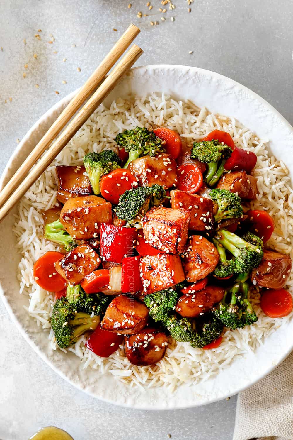 top view of Chinese honey garlic chicken served over rice garnished with sesame seeds