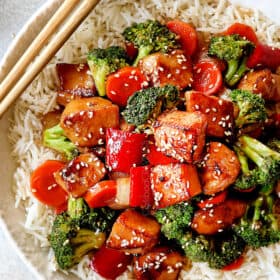 top view of Chinese honey garlic chicken served over rice garnished with sesame seeds