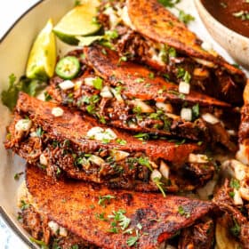 quesa birria taccos stuffed with birria de res, onions and cilantro