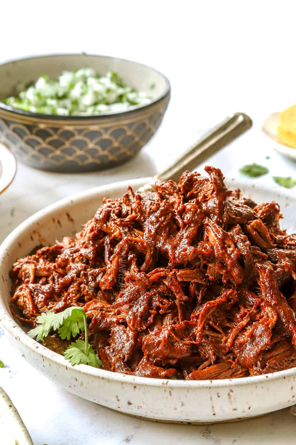 showing how to make birria recipe by adding shredded birria to a bowl