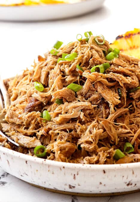 a bowl of Kalua pork recipe garnished with green onions