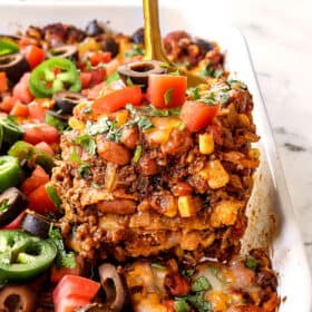 up close of a slice of beef enchilada casserole showing the different layers