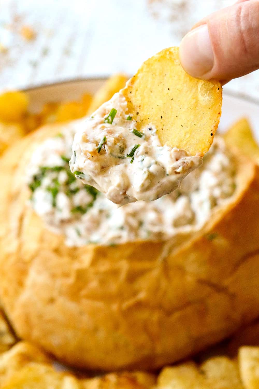 up close of a chip dunked in French Onion Dip recipe from scratch with caramelized onions