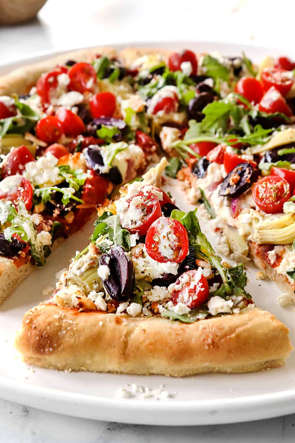 a slice of Greek pizza recipe showing how soft and chewy the crust is