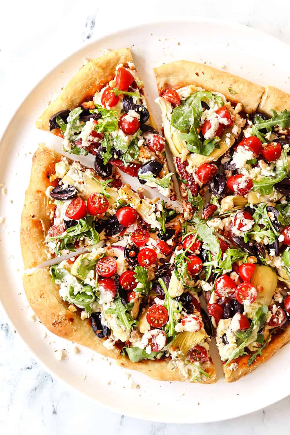 top view of showing how to use roasted red pepper sauce by adding it to pizza