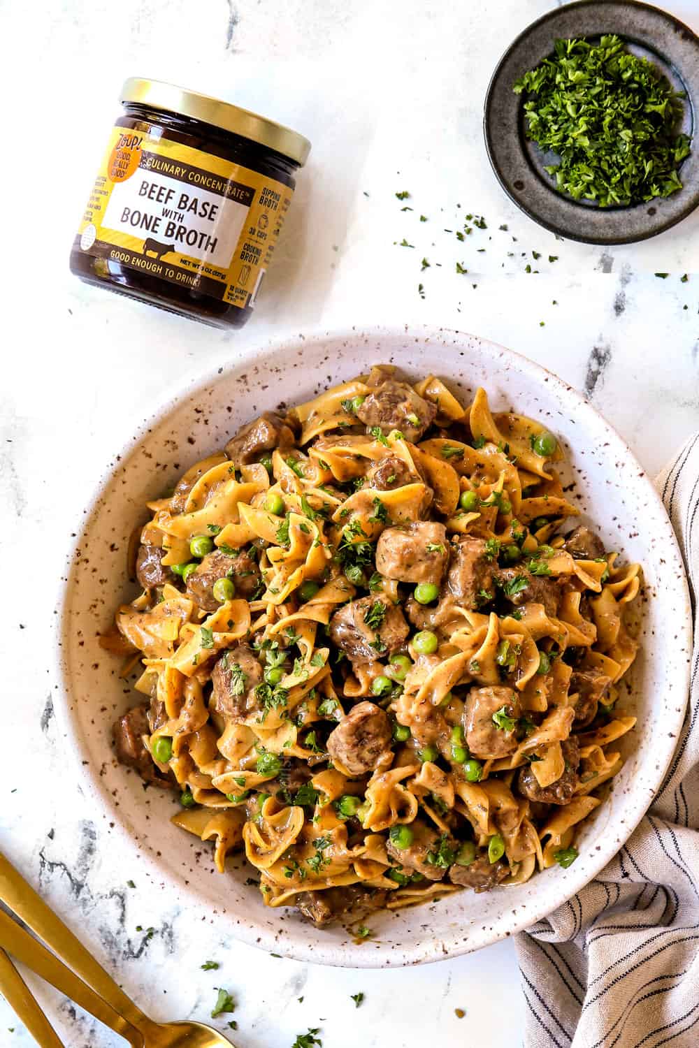 top view of serving beef tips and noodles in a bowl garnished with fresh parsley