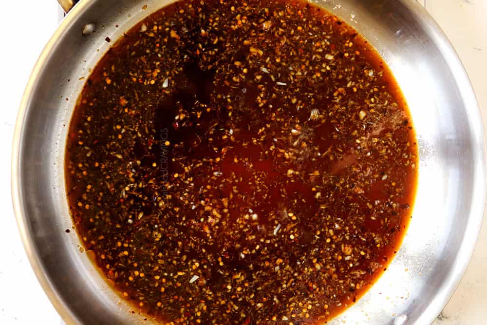 showing how to make ginger beef by simmering the sauce in a stainless steel skillet