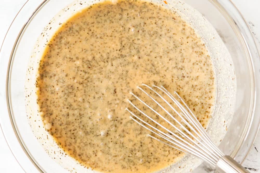 showing how to make peanut noodles recipe by whisking the sauce ingredients together in a glass bowl