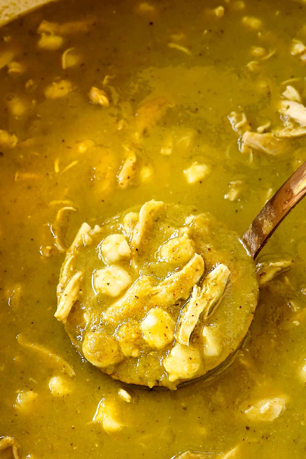 showing how to make chicken pozole (posole) by scooping up soup in a ladle