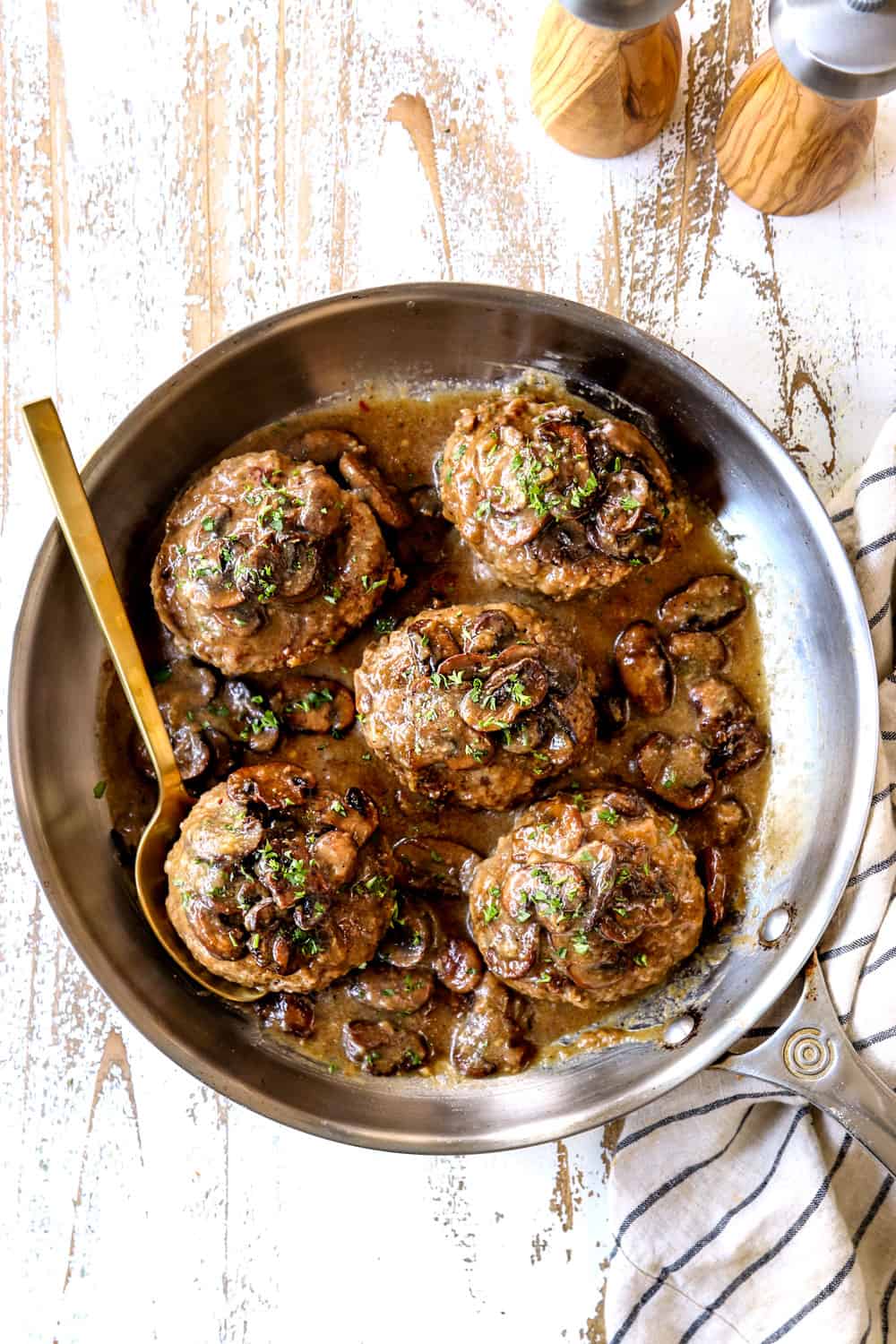 top view of Salisbury Steak recipe with mushroom gravy with a gold ladle