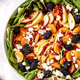 Mandarin Orange Salad with mandarins, apples and blackberries in a white bowl