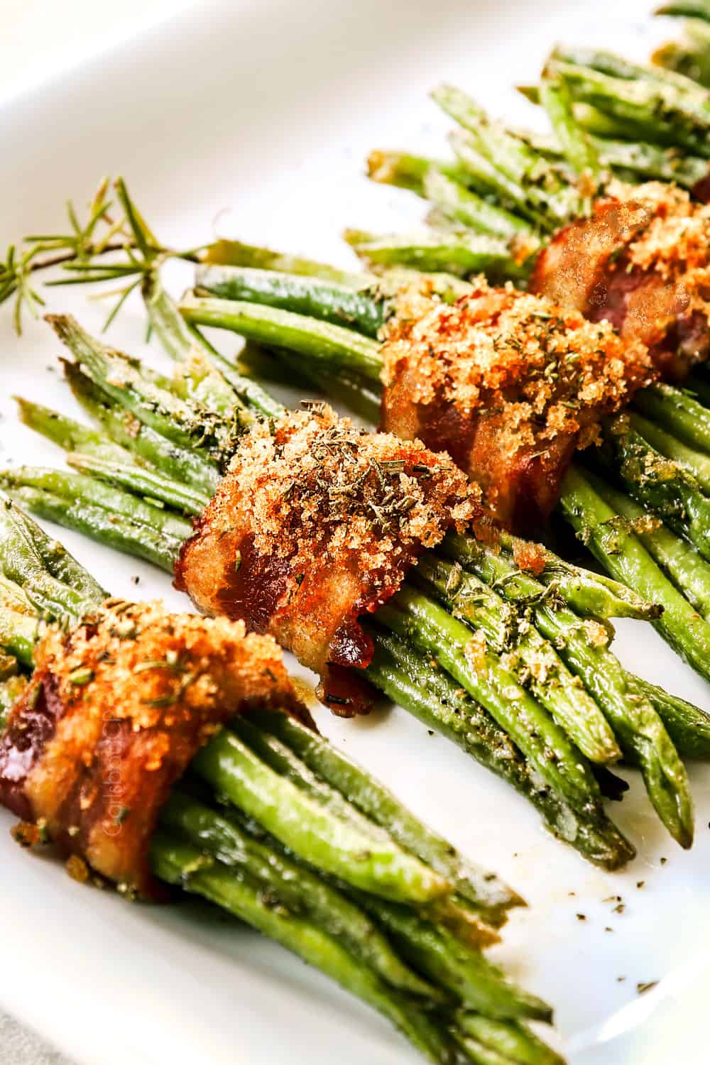 up close of bacon wrapped green bean bundles with crispy bacon