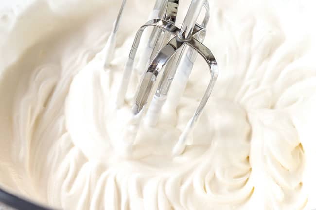 showing how to make Butterfinger pie by whipping heavy cream until stiff peaks form