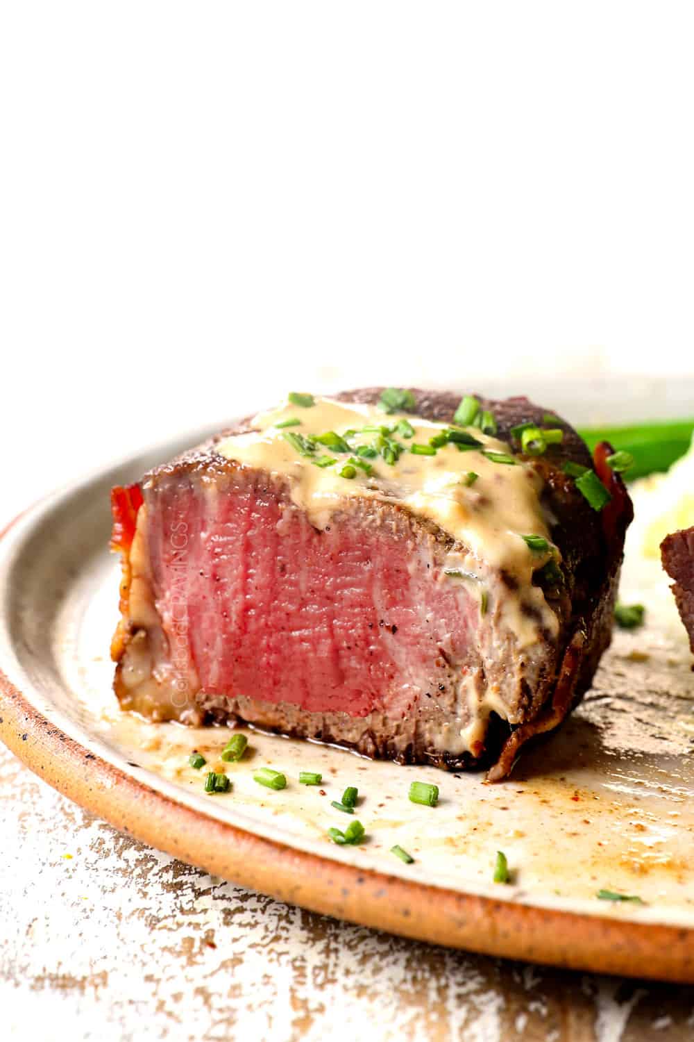 up close of medium rare filet mignon with filet mignon sauce sliced open