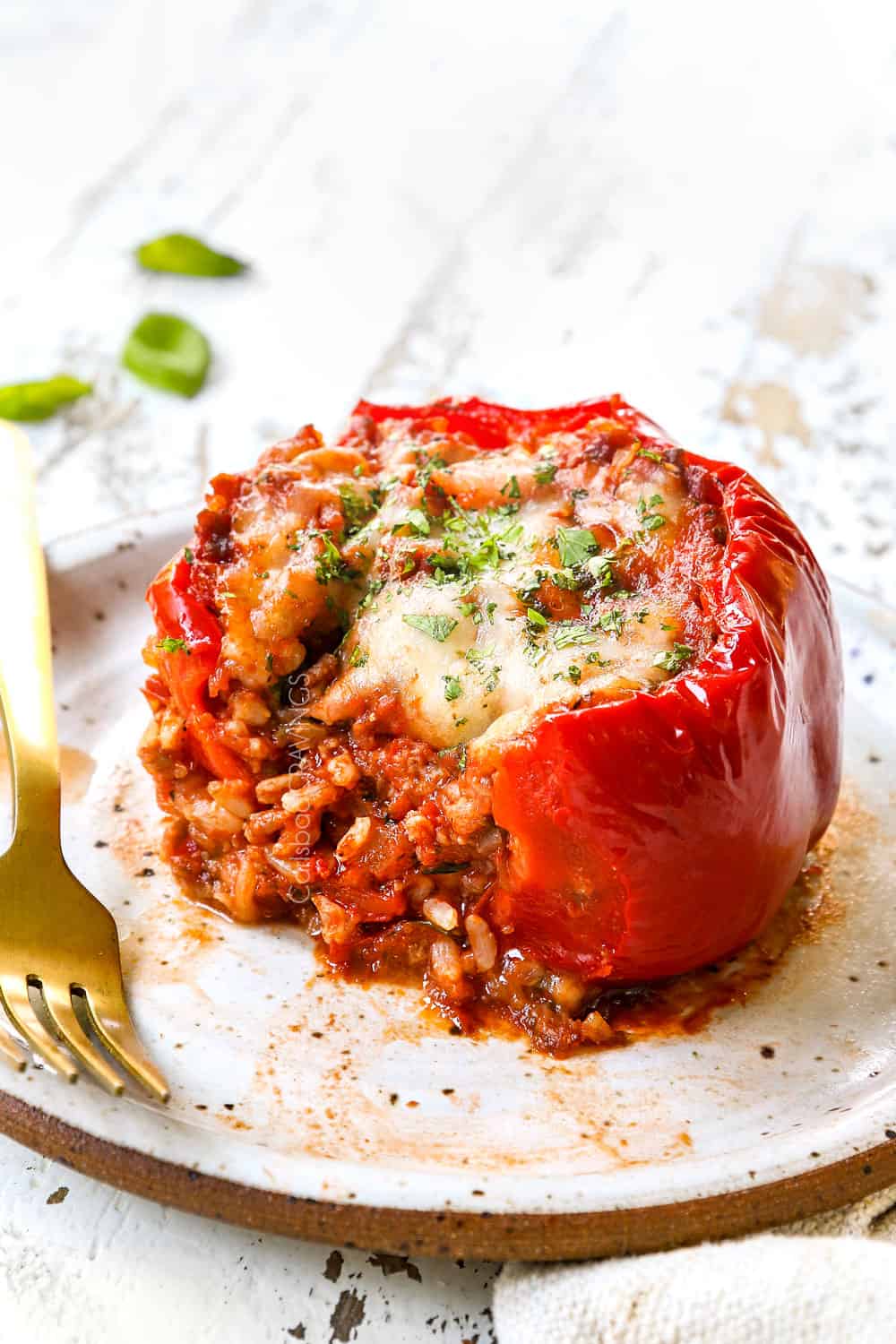 up close of a bite taken out of stuffed bell pepper showing the filling with rice and Italian sausage