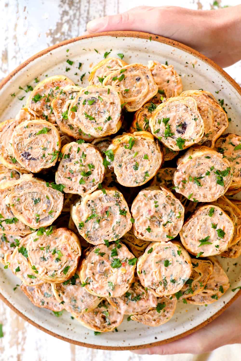 holding a platter of pinwheel recipe