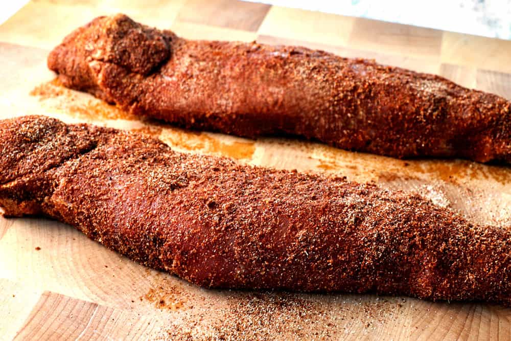 showing how to use pork tenderloin dry rub by coating all sides of the pork on a cutting board with the seasonings