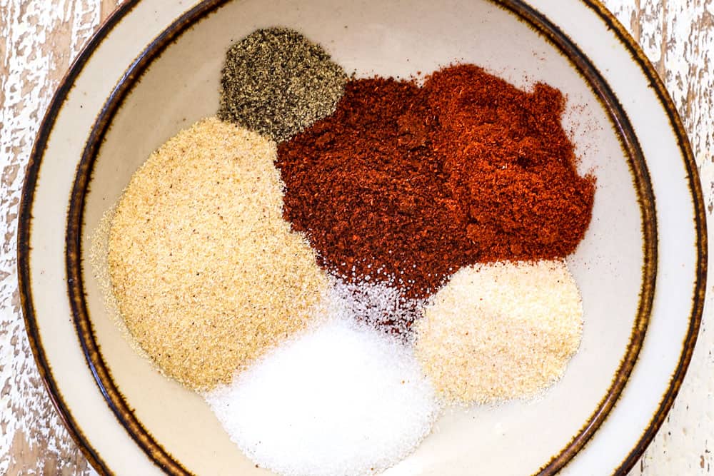 showing how to make dry rub for pork tenderloin by adding chili powder, paprika, salt, onion powder, garlic powder and pepper in a bowl