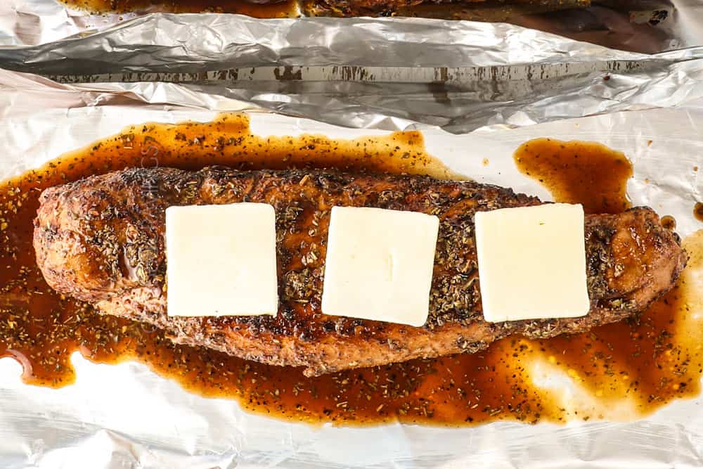showing how to cook pork tenderloin by adding butter on top of the seared pork before it is oven roasted