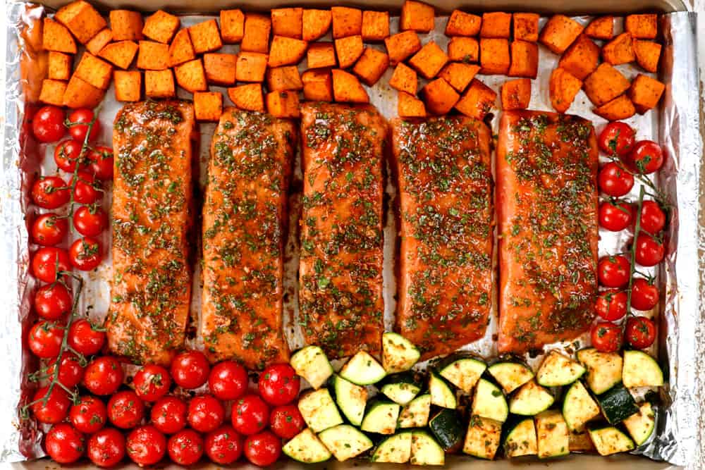 showing how to make baked salmon recipe by lining marinated salmon fillets on a baking dish