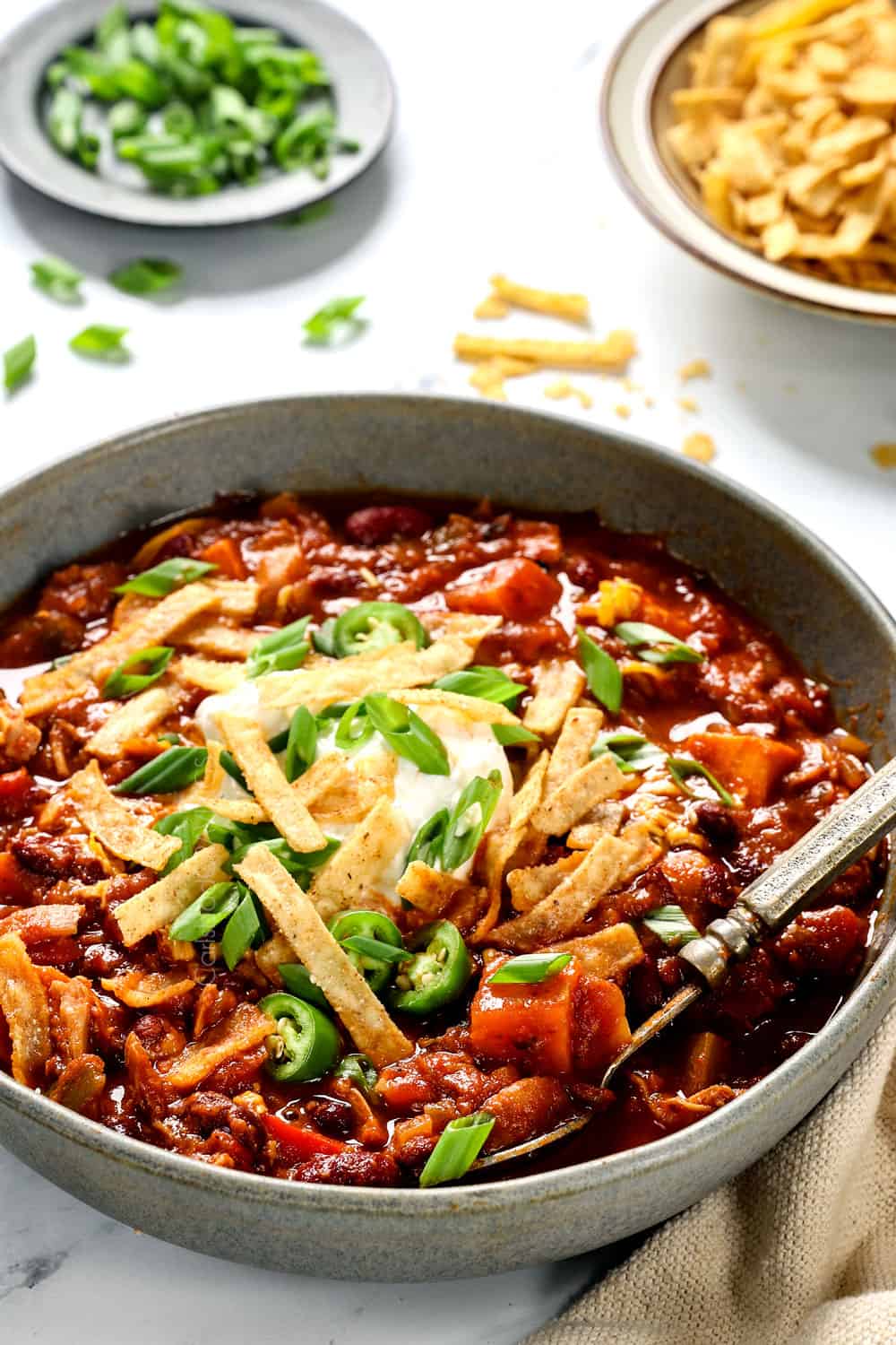 a bowl of healthy chicken chili with a spoon showing how thick it is