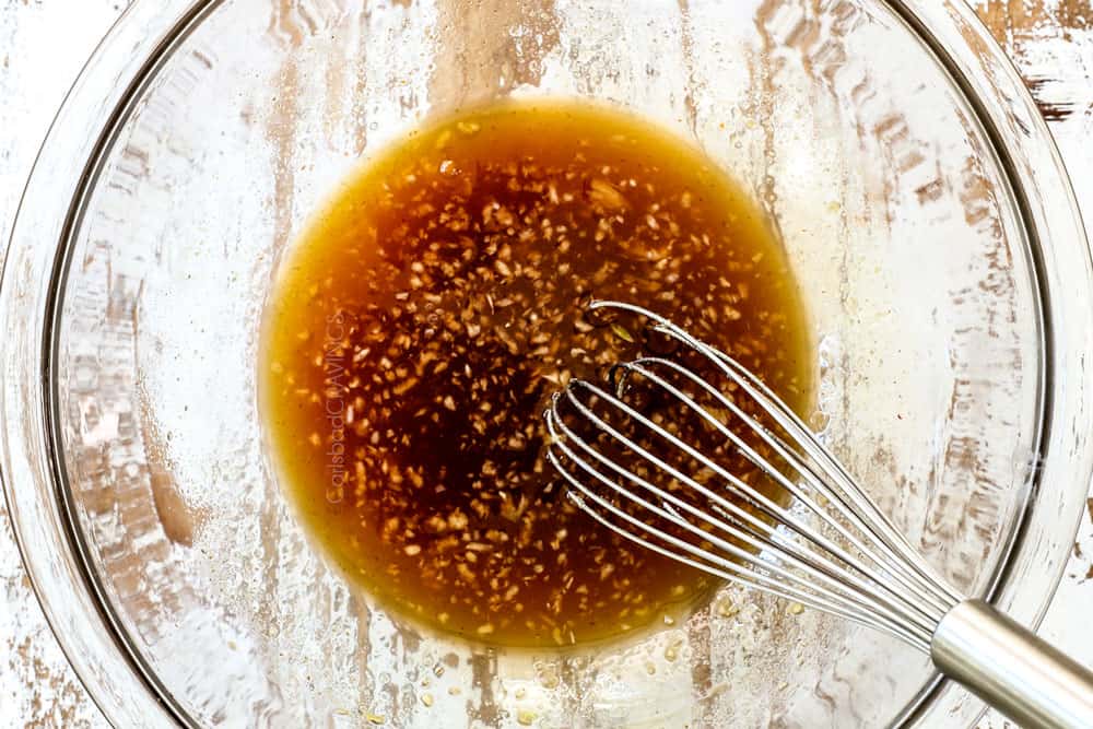 showing how to make honey lime chicken by whisking the sauce together in a glass bowl