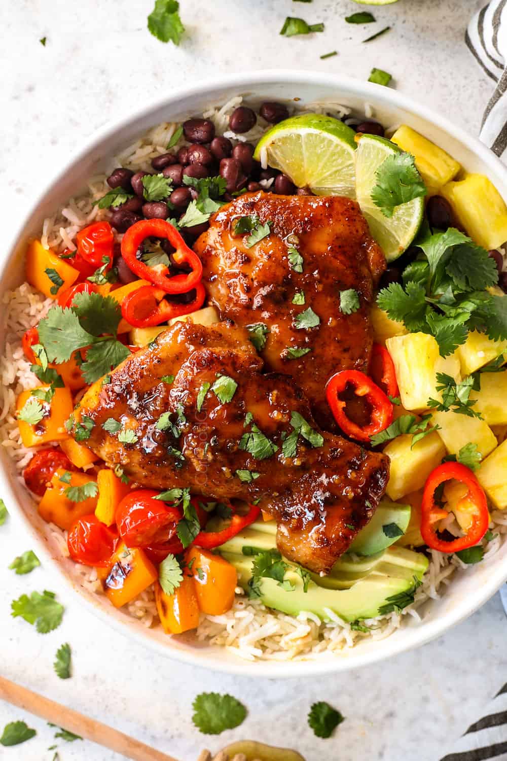 showing how to serve honey lime chicken with a top view of chicken in a grain bowl with vegetables, black beans and avocados