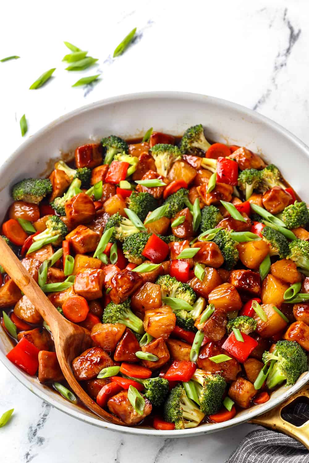 showing how to make teriyaki chicken stir fry recipe by garnishing with green onions