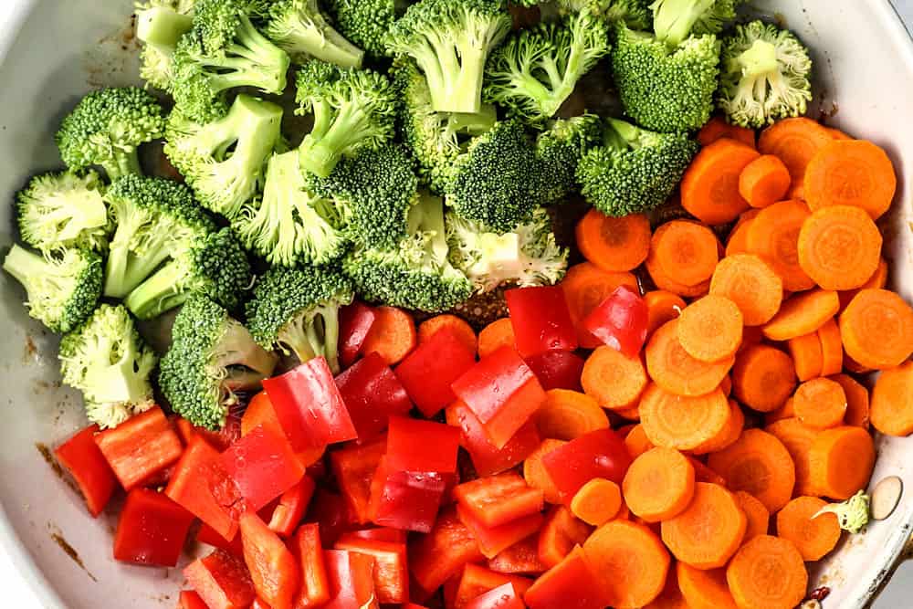 how to make teriyaki chicken stir fry by adding broccoli, bell peppers and carrots to a hot skillet
