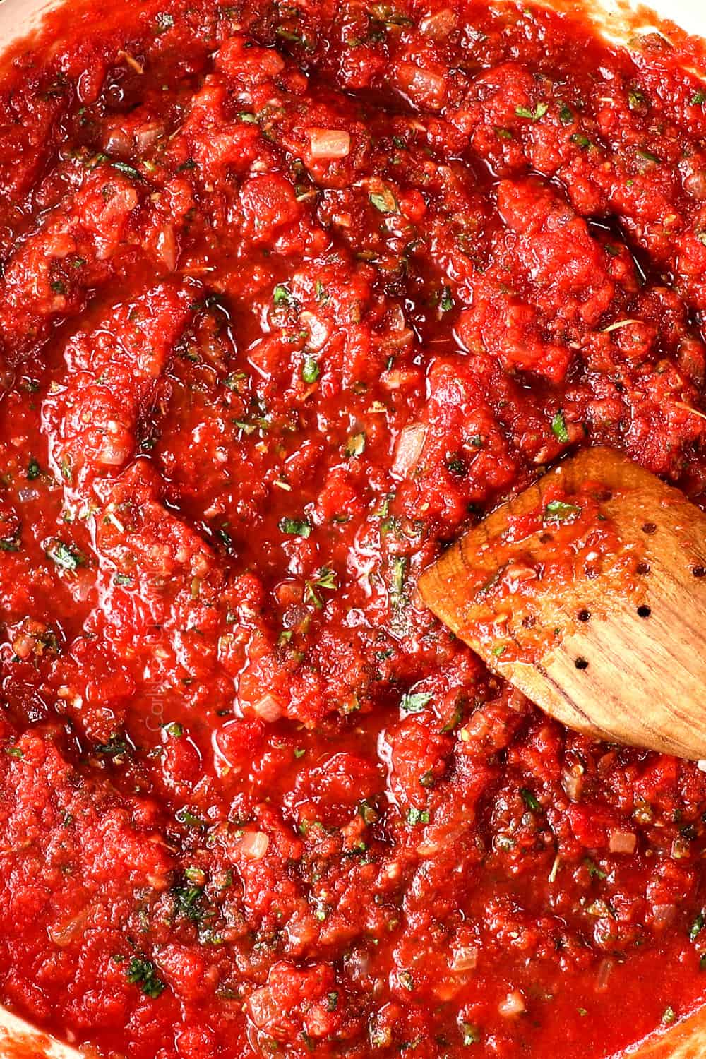 top view of stirring tomato sauce recipe