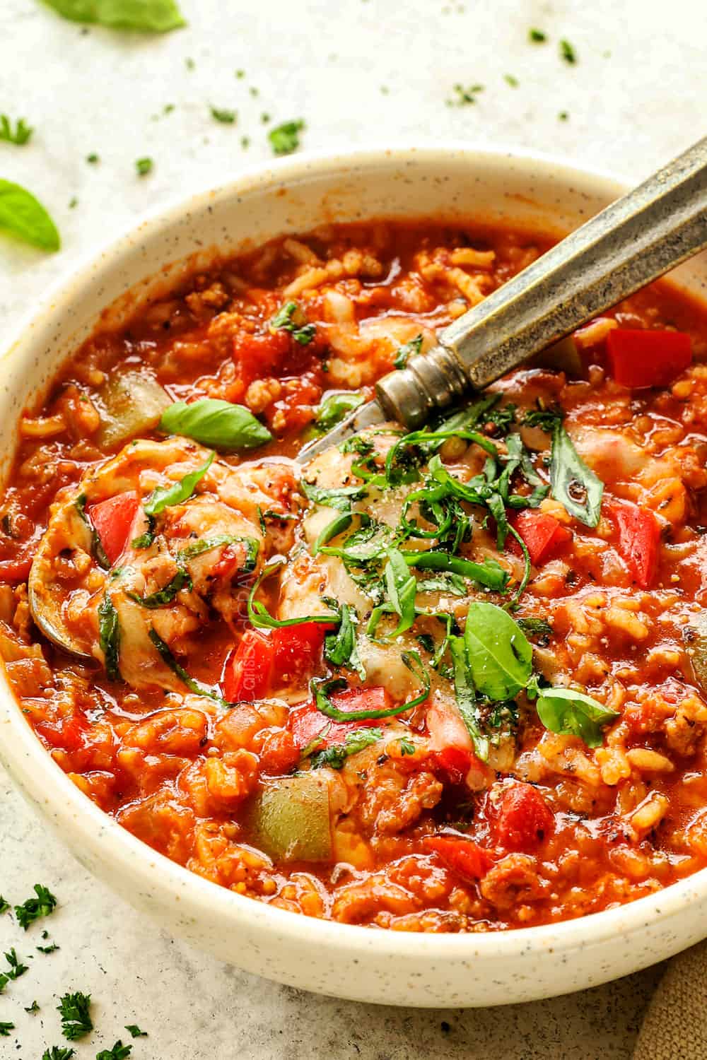 a bowl of stuffed pepper soup recipe garnished with mozzarella and fresh basil