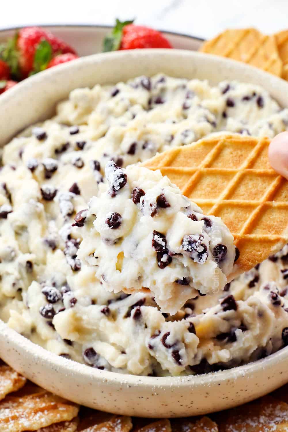 up close of cannoli dip on a waffle cookie dipper showing what to serve it with