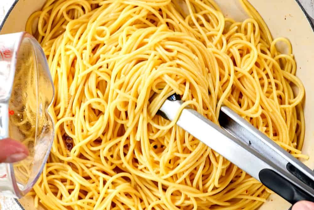 showing how to make carbonara recipe by tossing spaghetti with the pork grease and ยฝ cup starchy pasta water