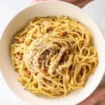 top view of spaghetti carbonara garnished with pecorino Romano and pepper