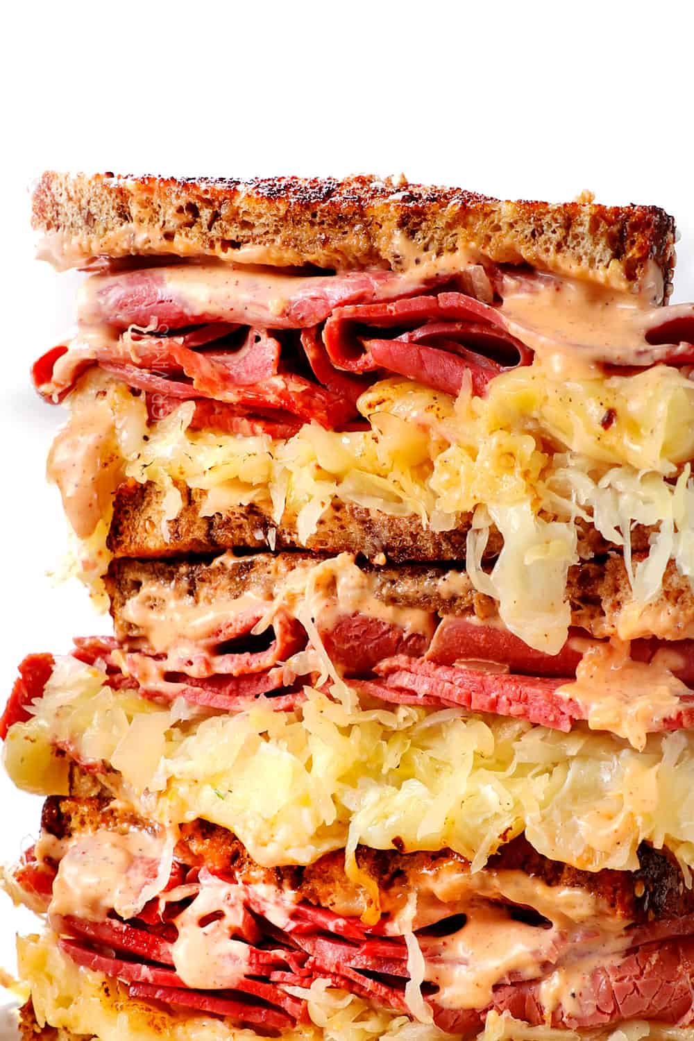 up close of Reuben sandwich sliced and stacked showing how cheesy it is