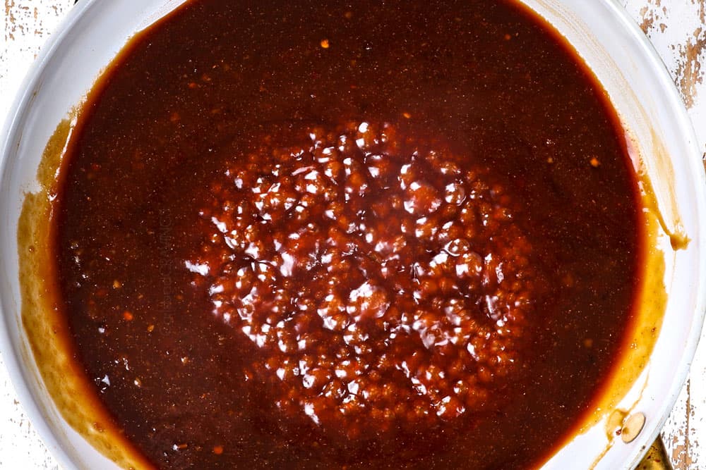 showing how to make sesame chicken by simmering sesame sauce in a skillet